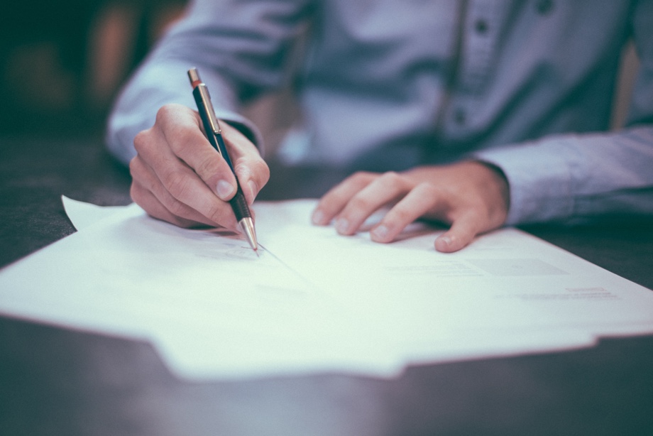 A man using a pen to sign a document